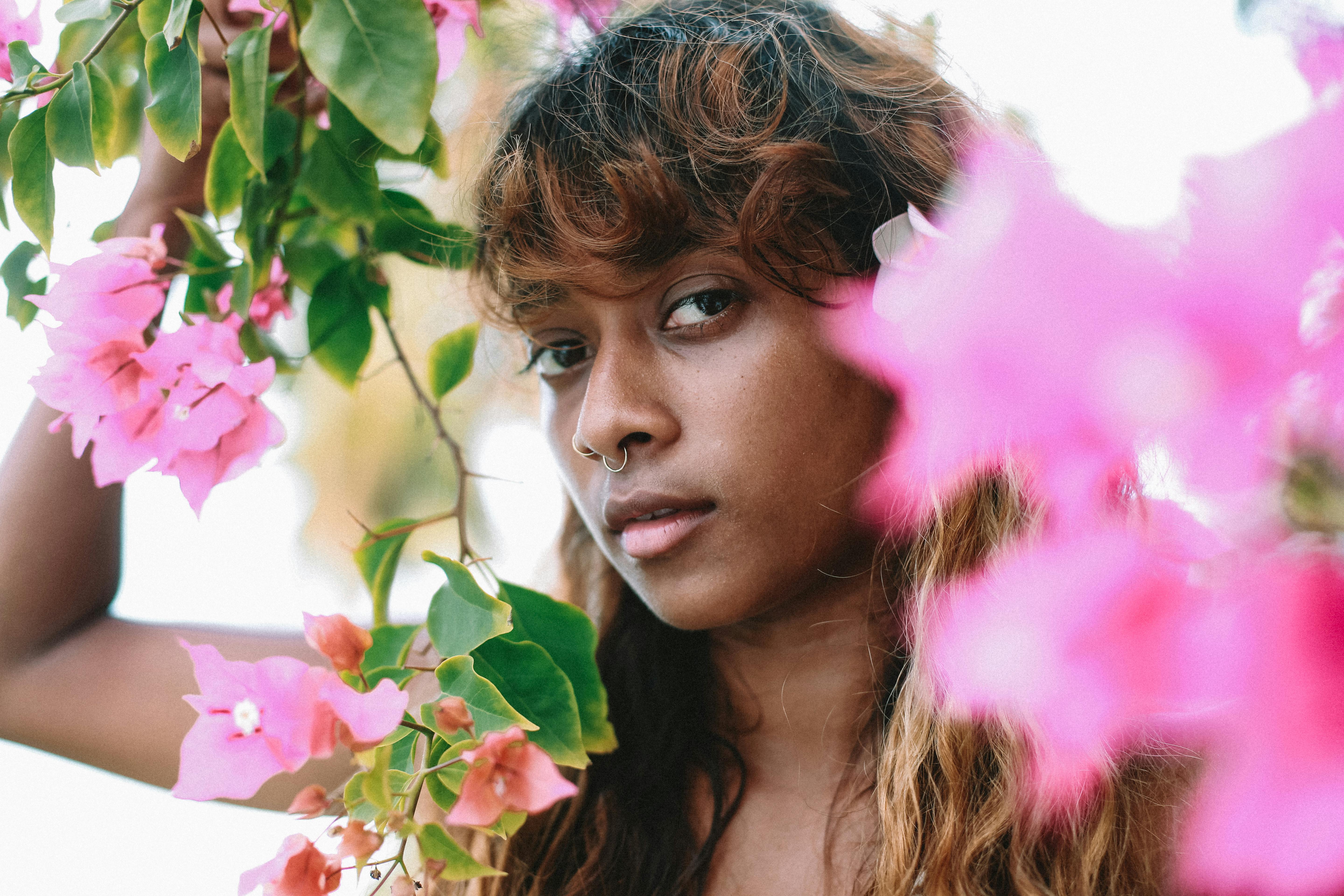 一幅特写肖像捕捉了女人与粉色花朵的宁静之美