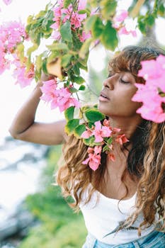 A woman enjoying nature surrounded by vibrant pink bougainvillea flowers.