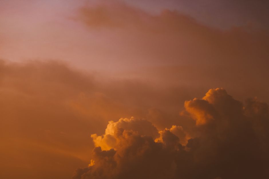A tranquil cloudscape during sunset with warm orange and purple tones, perfect for a calming mood.