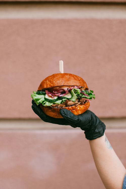 Gloved Hand Holding Burger