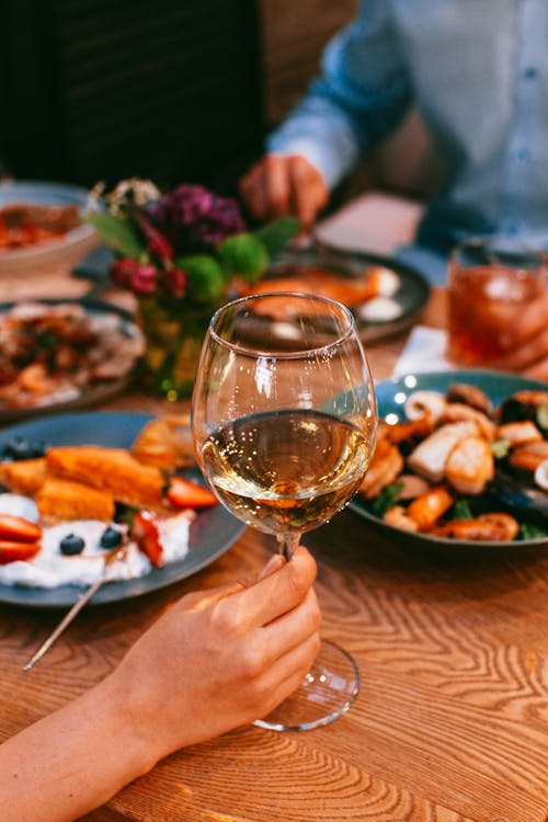 People at a Restaurant Eating and Drinking Wine 