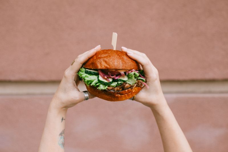 Crispy chicken burger held in hands