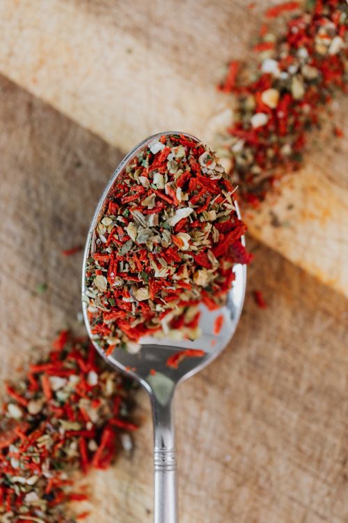Free Close-up of mixed herbs and spices on a spoon over wooden surface. Stock Photo