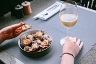 Person Holding Clear Wine Glass With Brown Liquid