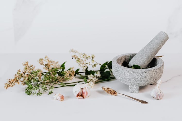 Edible Flowers And Mortar And Pestle With Ground Leaves