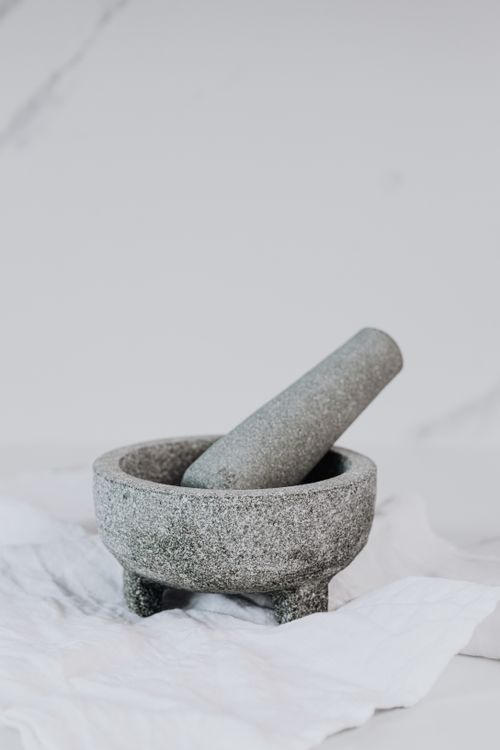 Free Granite mortar and pestle on white fabric, perfect for kitchen and culinary themes. Stock Photo