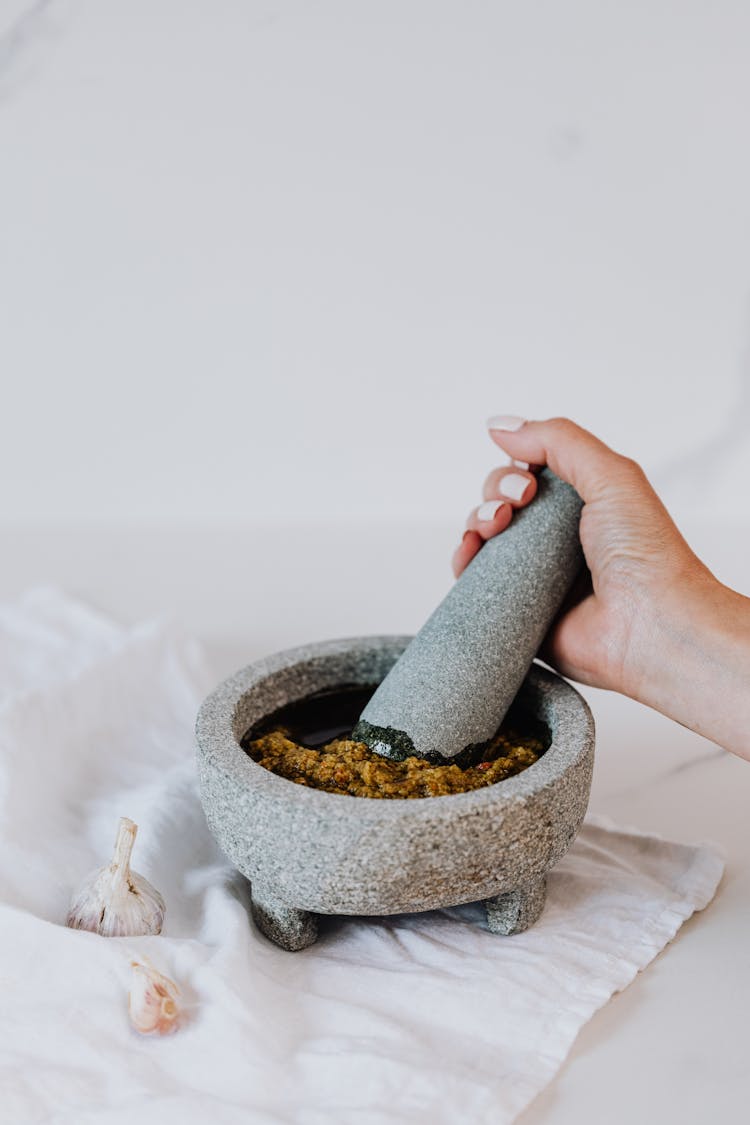 Person Holding Grinding Using Mortar And Pestle