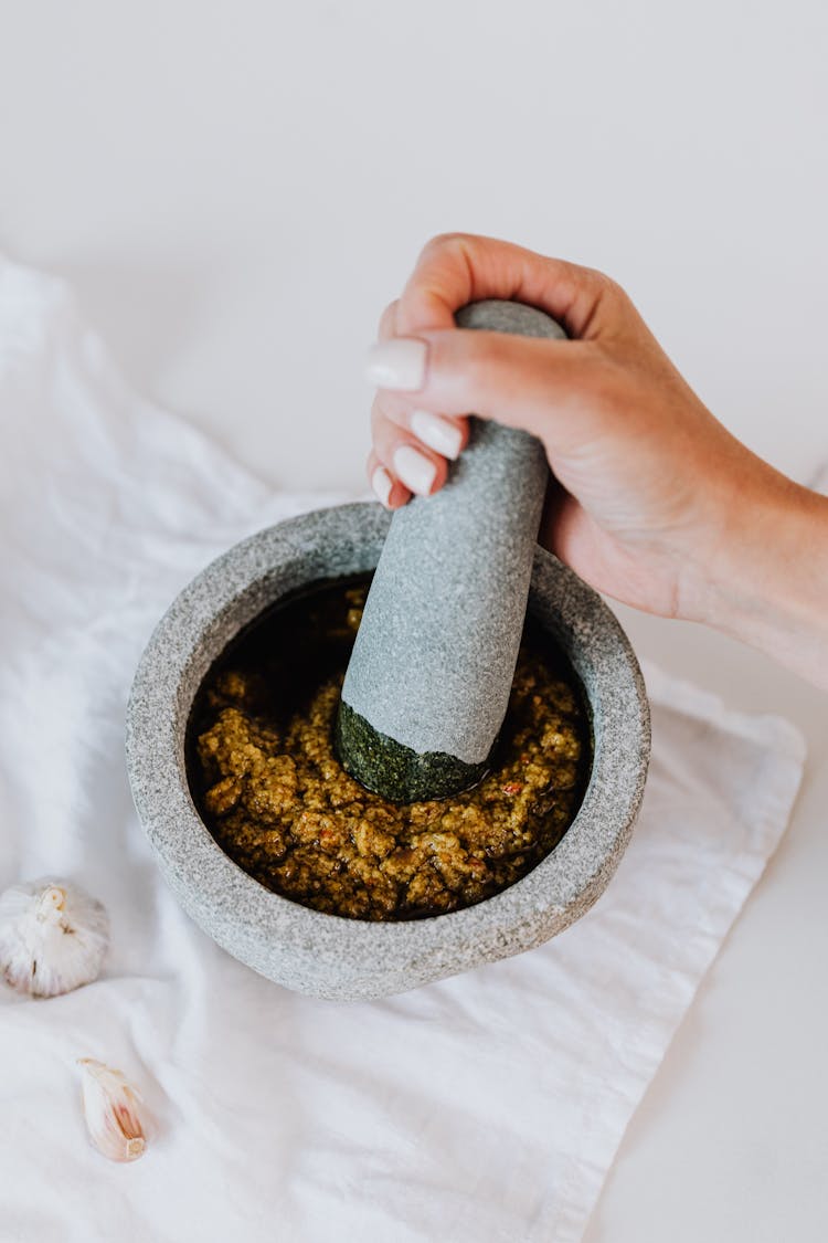 Person Holding Grinding Using Mortar And Pestle