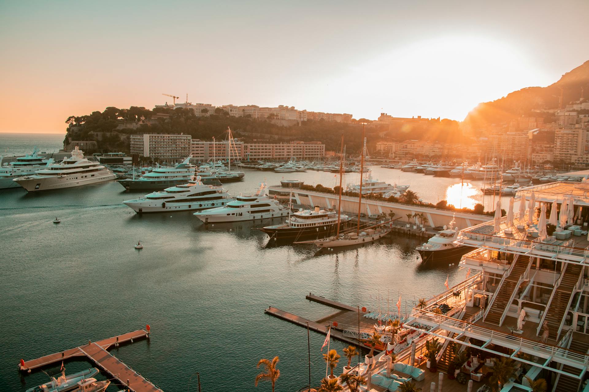 Stunning view of yachts in Monaco harbor at sunset, showcasing luxury and tranquility.