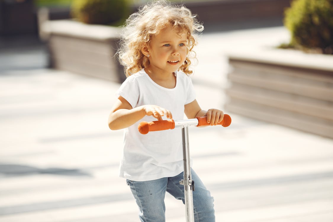 A Girl Riding a Scooter 