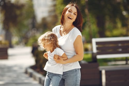 Free A happy mother and daughter enjoying a sunny day, sharing laughter in a park. Stock Photo
