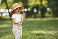 Girl in White Dress Holding Yellow Lollipop