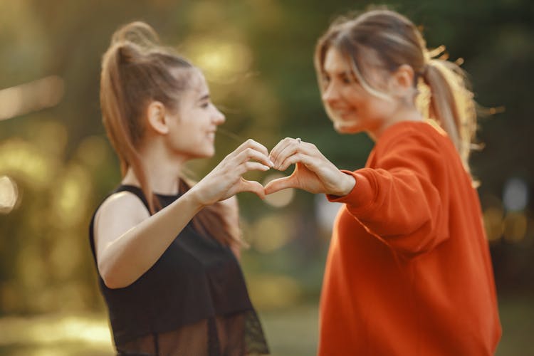 Photograph Of Girls Forming A Heart Shape With Their Hands