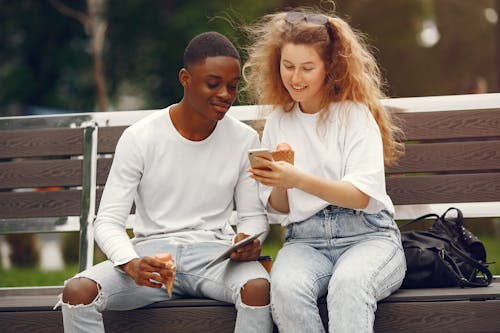 Free A Man and a Woman Sitting on a Bench Stock Photo