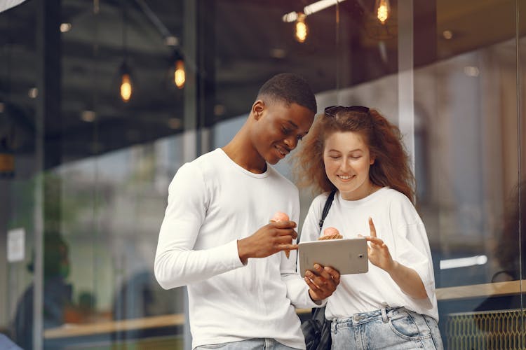 A Man And A Woman Using An Ipad