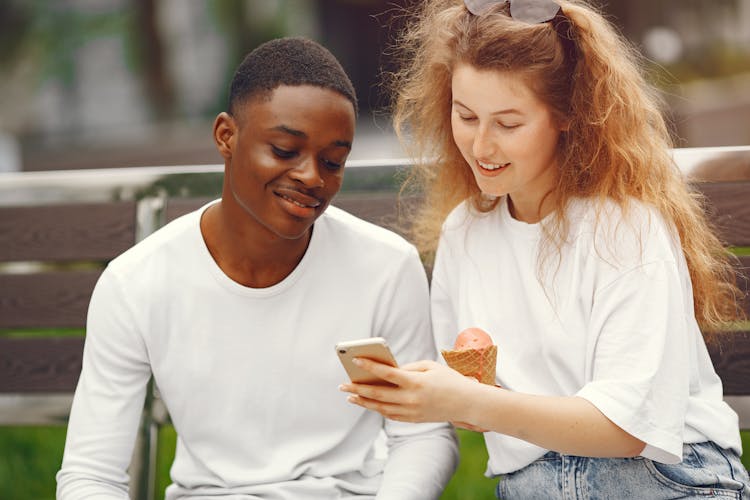 A Couple Looking At A Smart Phone