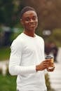 A Smiling Man in White Long Sleeve Shirt Holding a Coffee