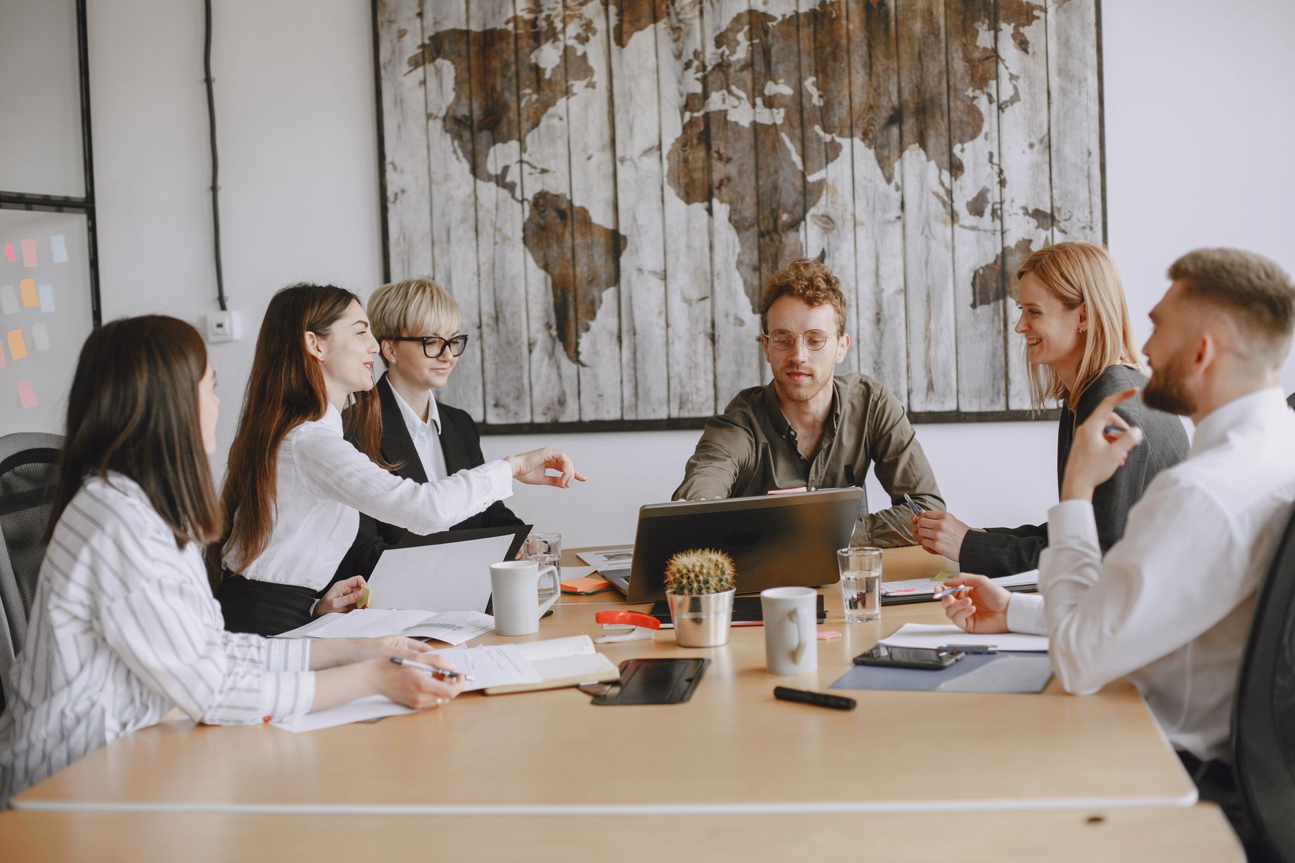 Business team discussing a project around a table indoors.
