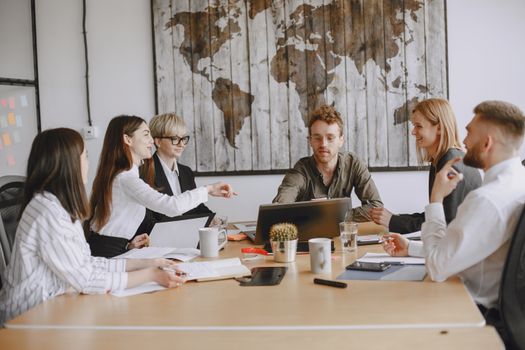 Business team discussing a project around a table indoors.