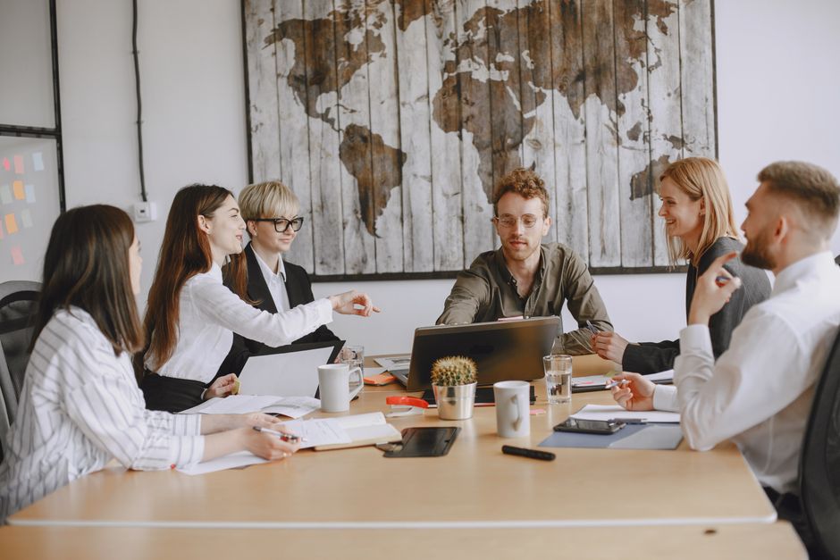 Business team discussing a project around a table indoors.