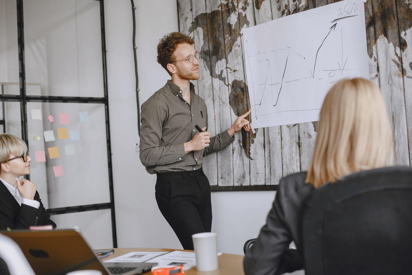 A presenter discussing a chart with colleagues in a conference room