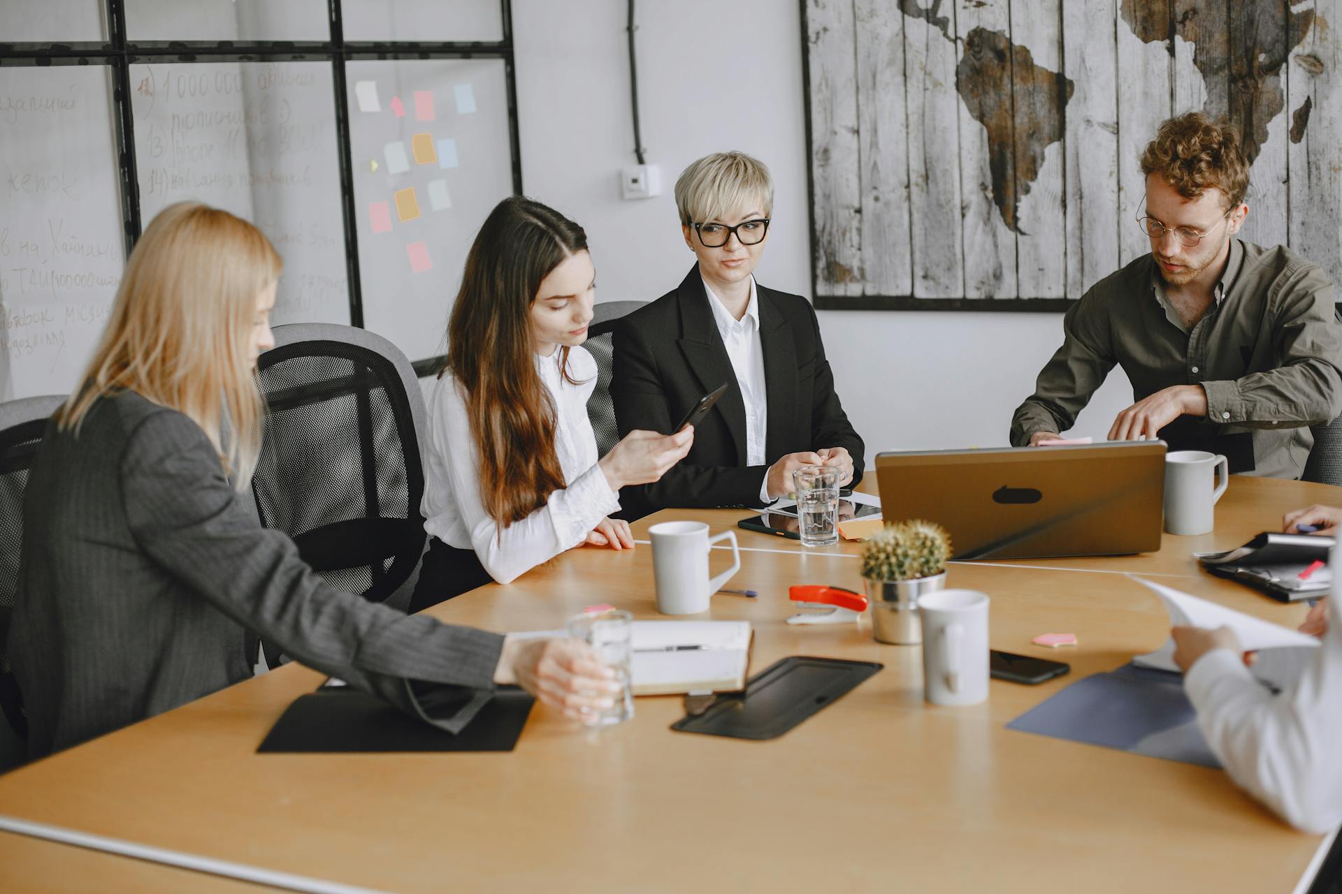 A group of business professionals working together at an office meeting table.