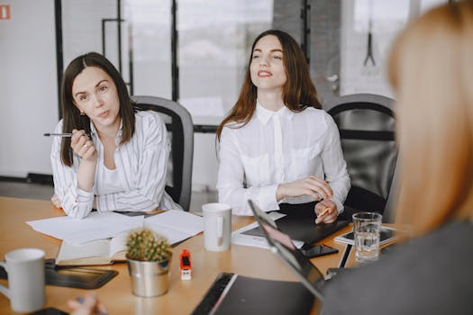 Professional businesswomen engaged in a collaborative office meeting.