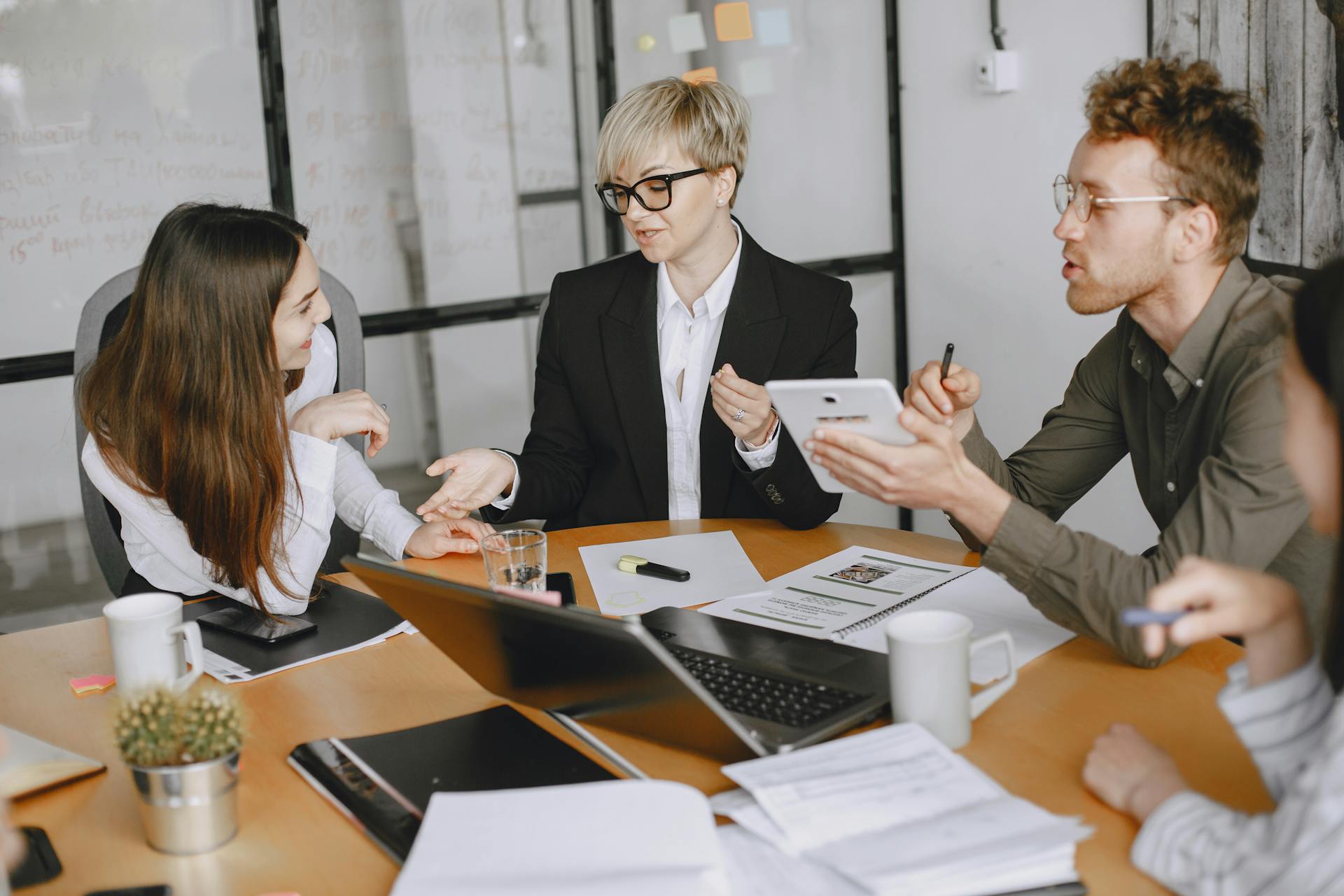 Group of business professionals engaged in a meeting discussing strategies and cooperation.