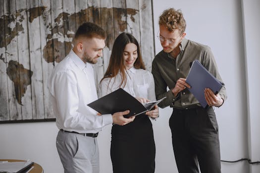 Professional team engaged in a meeting, reviewing documents together in a modern office space.