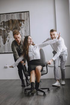 Colleagues having fun in an office, sharing joy during a work break.