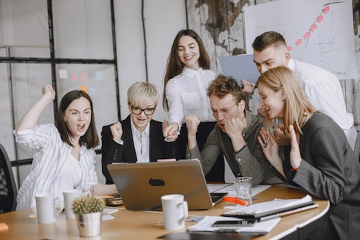 Group of diverse colleagues celebrating success in a modern office