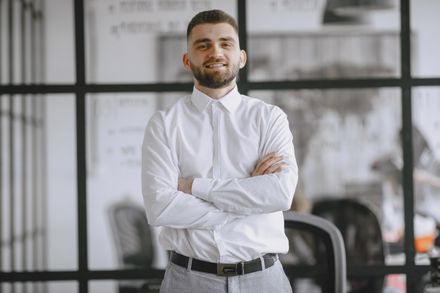 Portrait of a smiling businessman in a modern office — photo by Gustavo Fring on Pexels