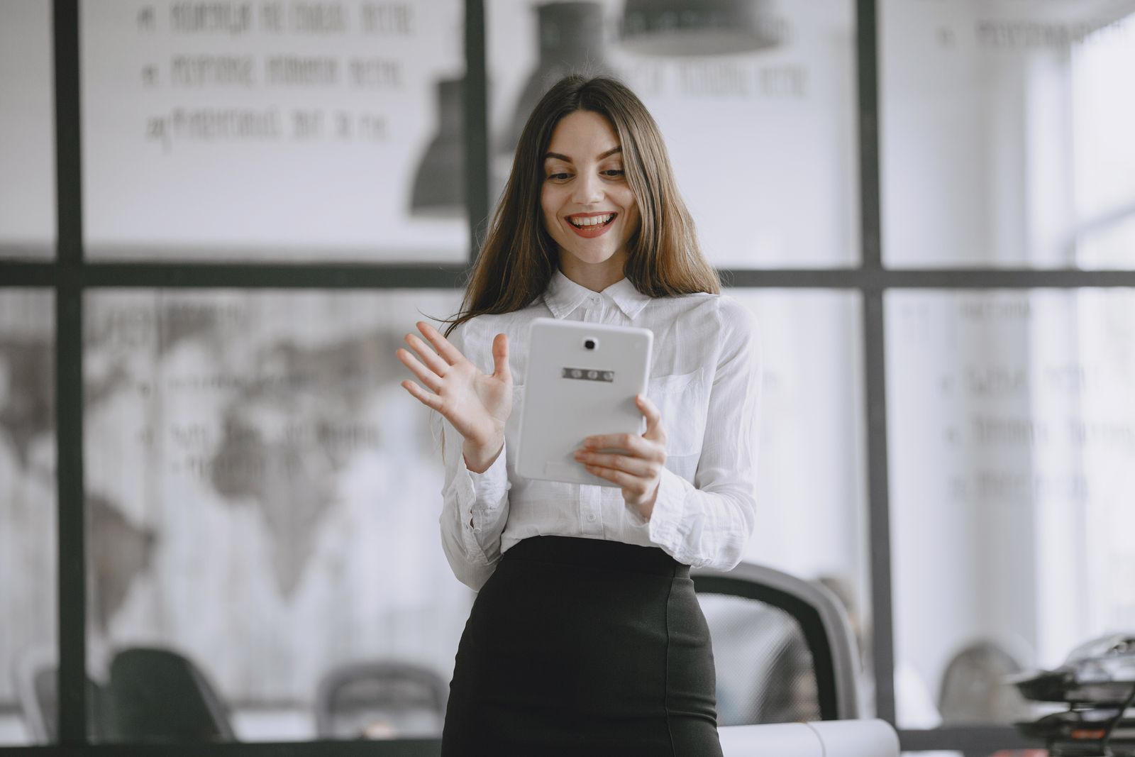 Maya Ellis smiling brightly as she works on a tablet in her office