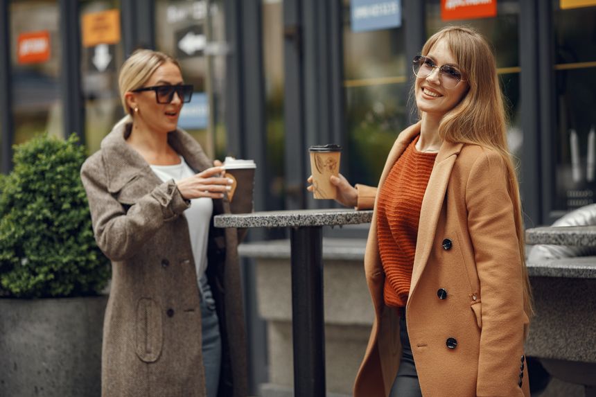 Two colleagues talking over coffee outside a cafe, photo by Gustavo Fring on Pexels