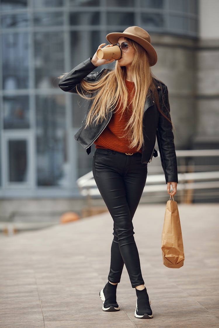 Woman Walking Down Street Drinking Takeout Coffee