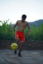 Man in Red Shorts Playing Yellow Soccer Ball