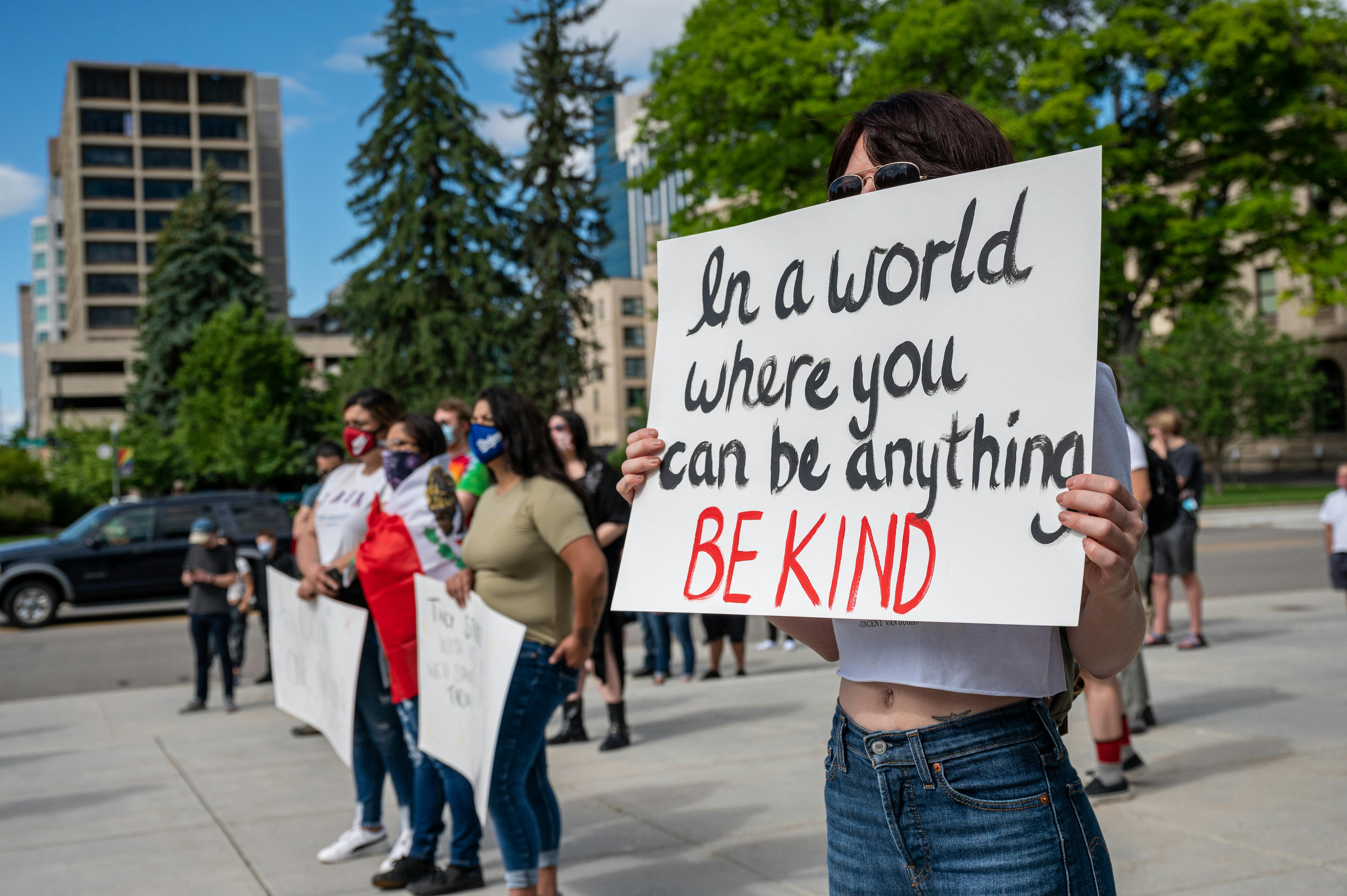 anonymous social justice warriors with placards during manifestation on street