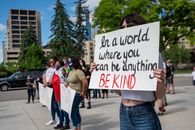 Anonymous social justice warriors with placards during manifestation on street