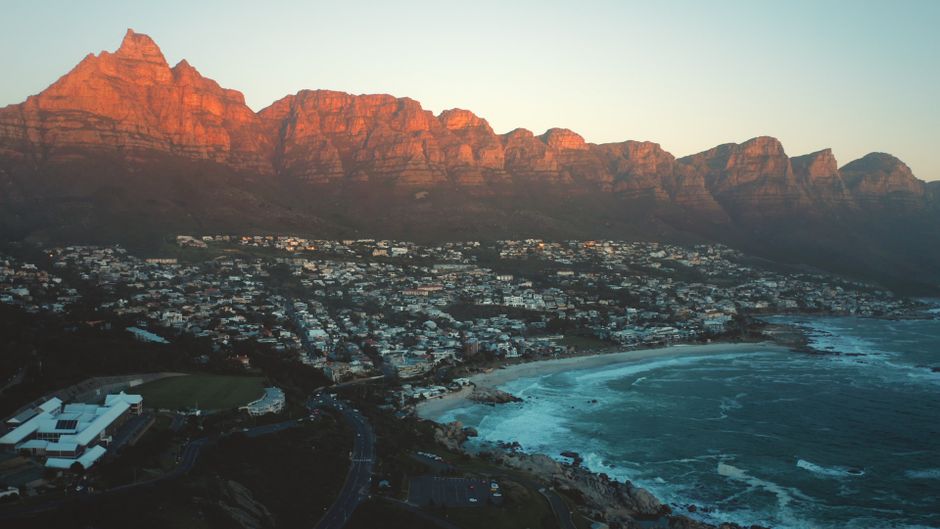 Outstanding Cape Town Helicopter Tour and Boulders Beach Penguins Tour Review Review 2026 - A breathtaking view of Cape Town's coastline with the iconic Twelve Apostles mountain range at sunset.