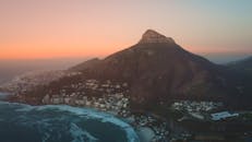 日落时开普敦和狮头山的壮丽鸟瞰图，展示了沿海景观