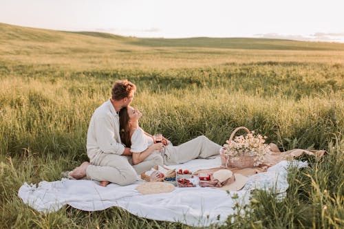 A Couple Having a Picnic  on a Grass Field