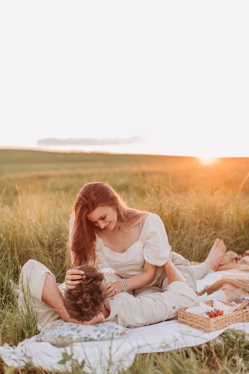 A Couple Having a Picnic on the Grass Field