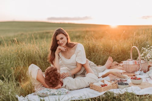 A Couple Having a Picnic on the Grass Field