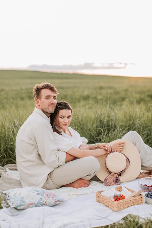 A Couple Having a Picnic on the Grass Field