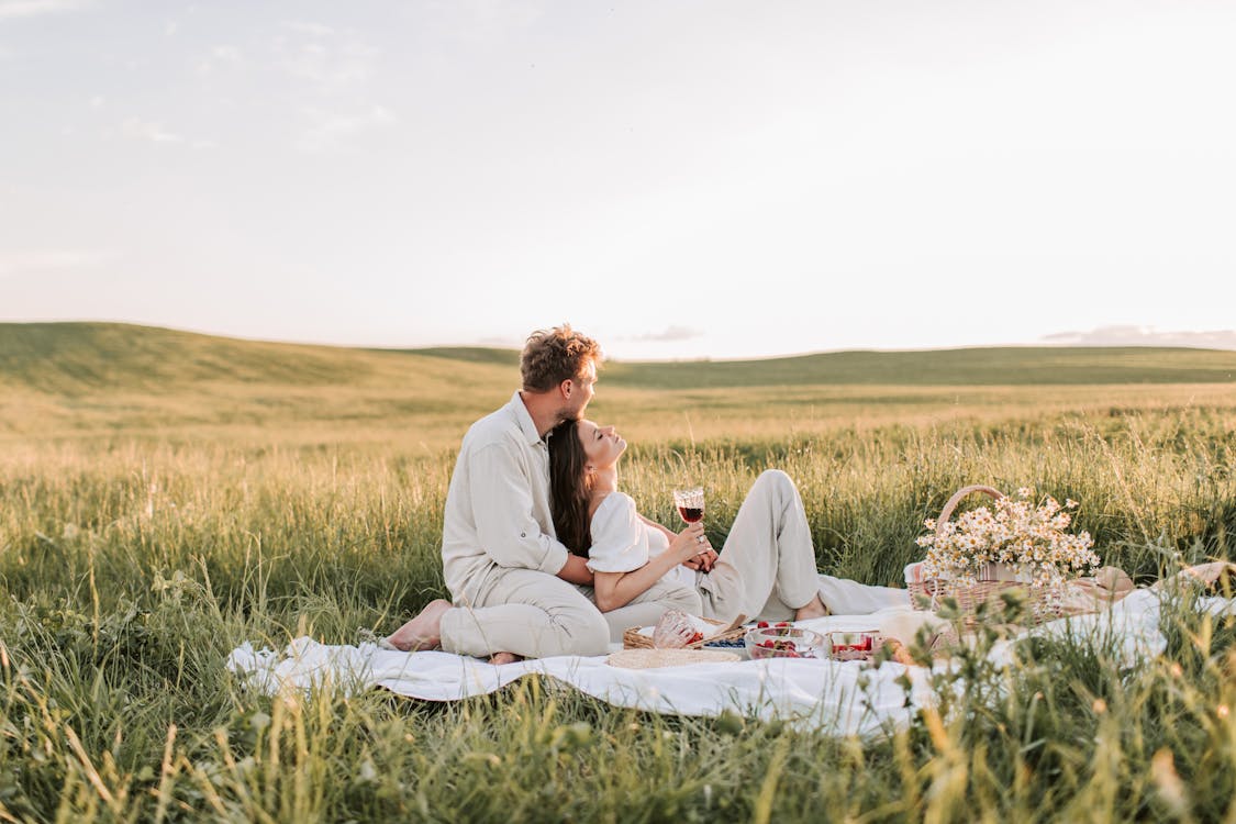 Free Man And Woman Sitting On Grass Field Stock Photo