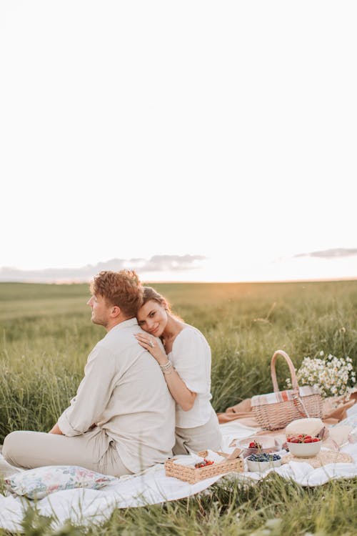 Free Man And Woman Sitting On Grass Field Stock Photo