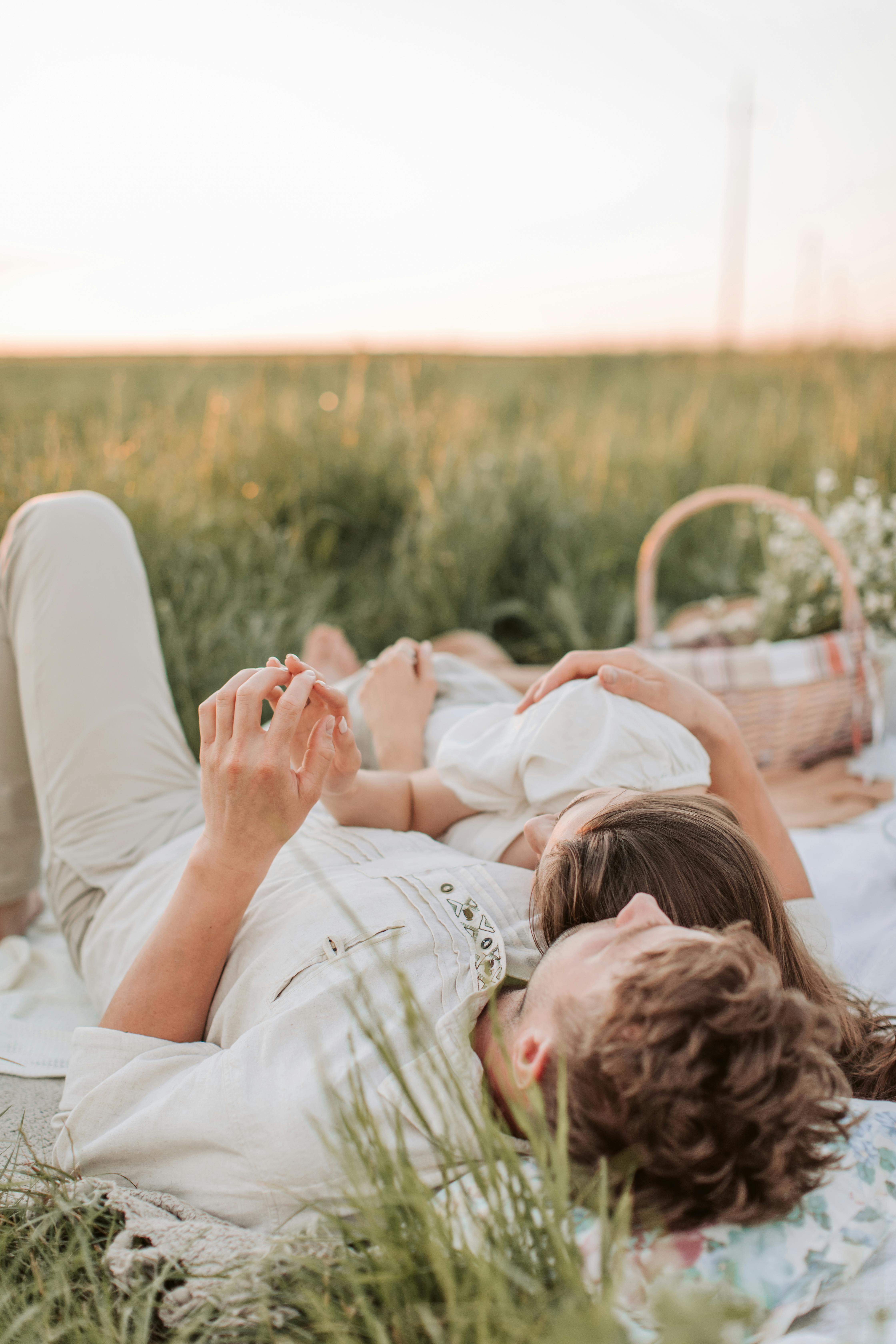一对夫妇在阳光明媚的草地上享受着浪漫的野餐，拥抱爱与团结