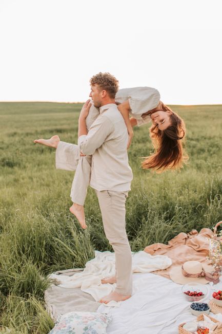 A couple in love playfully enjoying a summer picnic in a grassy field.