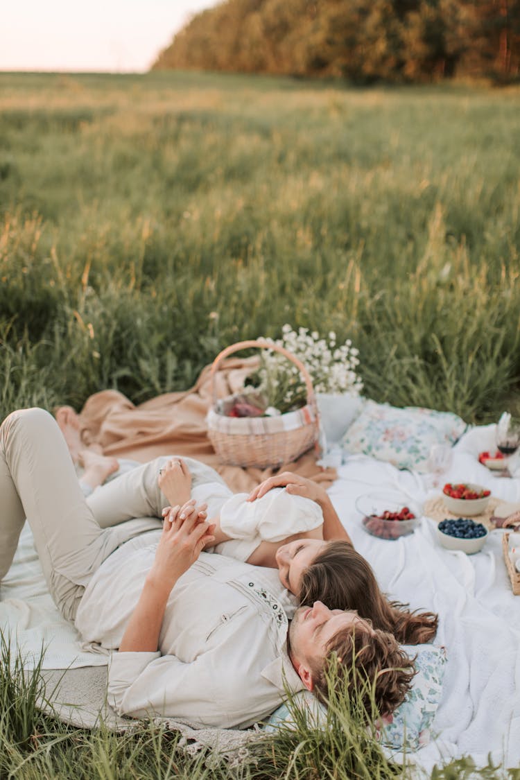 Man And Woman Lying On Picnic Blanket 