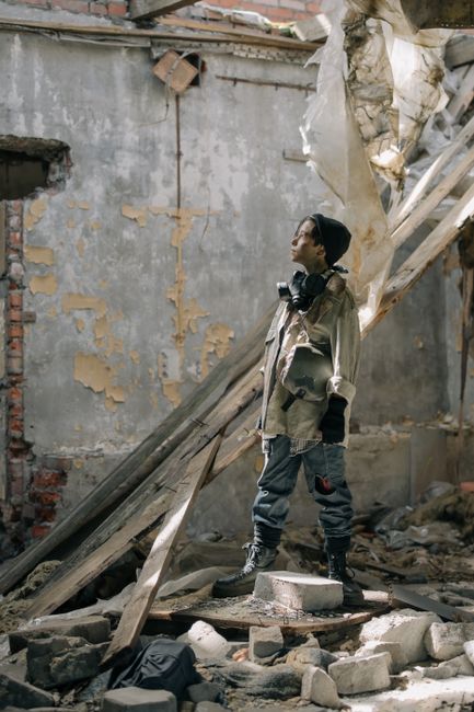Fotomural Un joven se encuentra entre las ruinas de un edificio en mal estado, embodying una sensación post-apocalíptica.